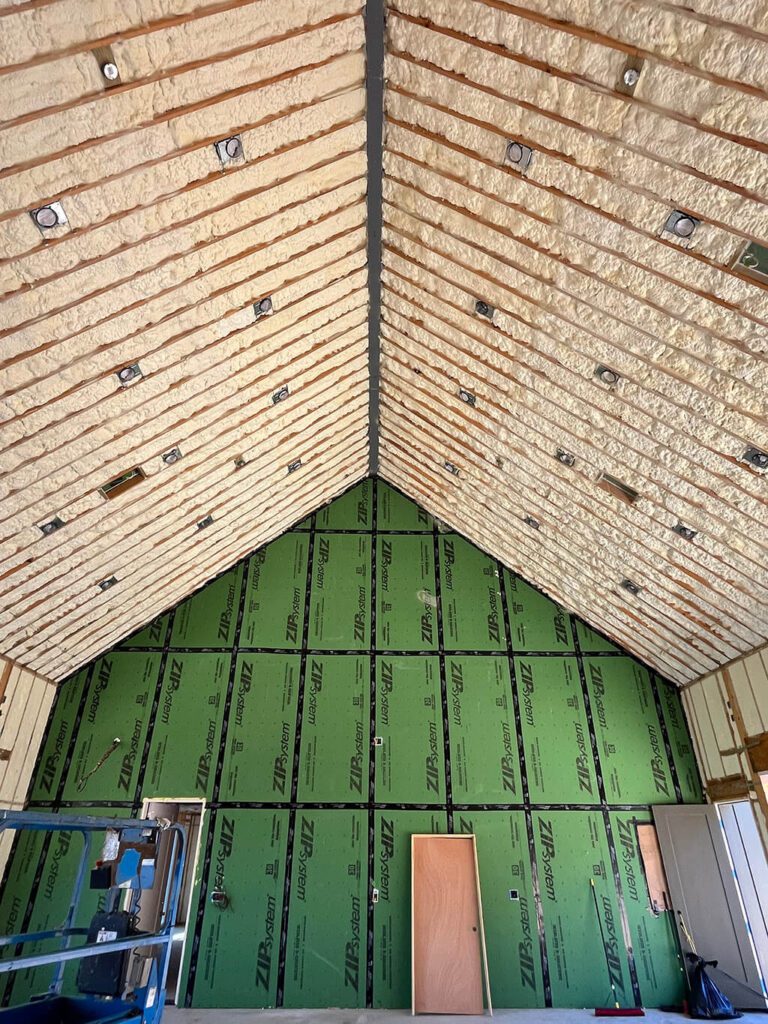 Vaulted attic ceiling with spray foam insulation and ZIP System wall sheathing for a high-performance, energy-efficient home seal.